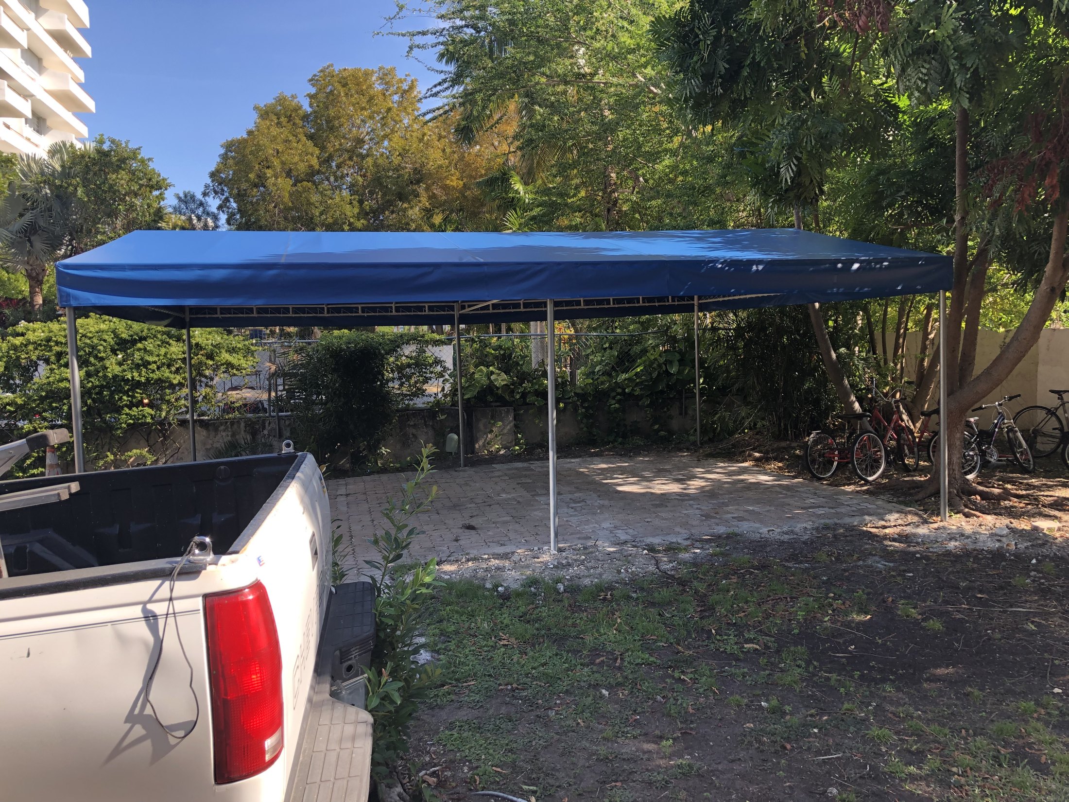 Blue freestanding carport installed beside a residential property